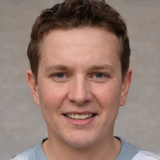 Joyful white adult male with short  brown hair and grey eyes