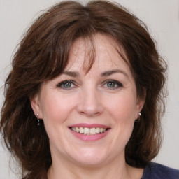 Joyful white adult female with medium  brown hair and grey eyes