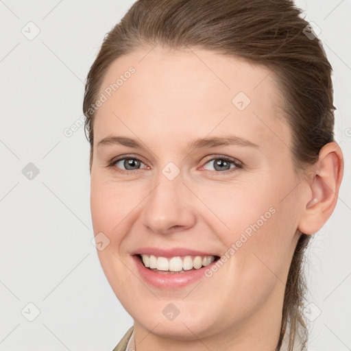 Joyful white young-adult female with medium  brown hair and grey eyes