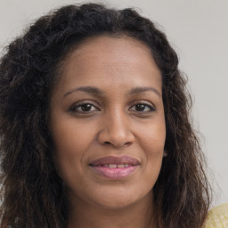 Joyful black young-adult female with long  brown hair and brown eyes