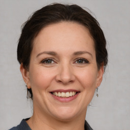 Joyful white adult female with medium  brown hair and grey eyes