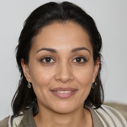 Joyful latino young-adult female with medium  brown hair and brown eyes