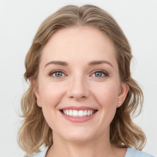 Joyful white young-adult female with medium  brown hair and blue eyes