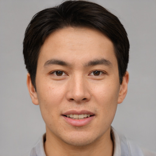 Joyful asian young-adult male with short  brown hair and brown eyes