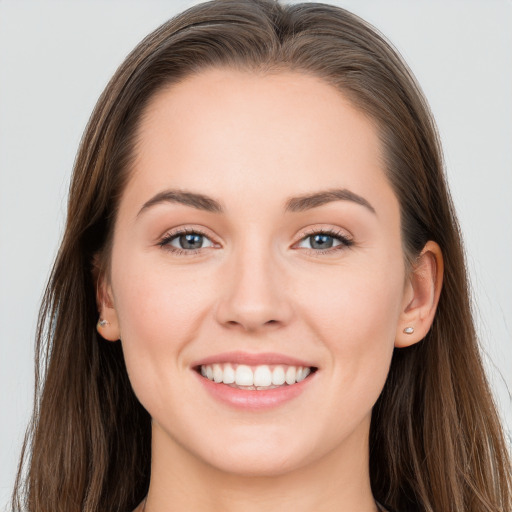 Joyful white young-adult female with long  brown hair and grey eyes