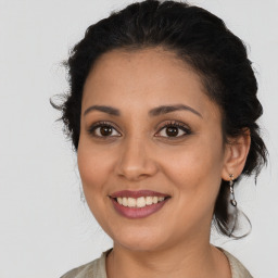 Joyful latino young-adult female with medium  brown hair and brown eyes