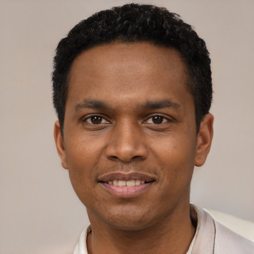 Joyful black young-adult male with short  black hair and brown eyes