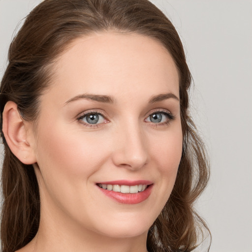 Joyful white young-adult female with long  brown hair and grey eyes