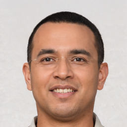 Joyful white young-adult male with short  black hair and brown eyes