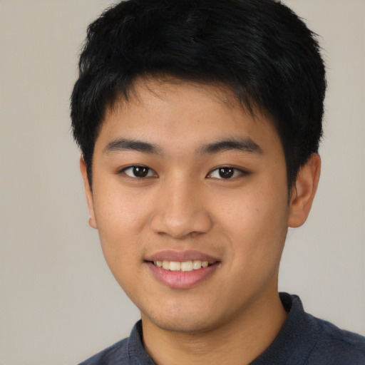 Joyful asian young-adult male with short  black hair and brown eyes