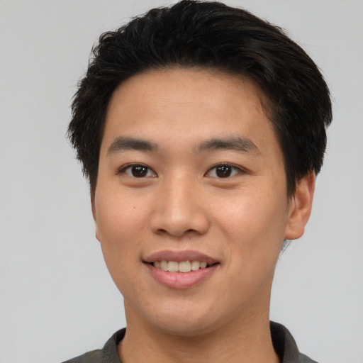 Joyful asian young-adult male with short  brown hair and brown eyes