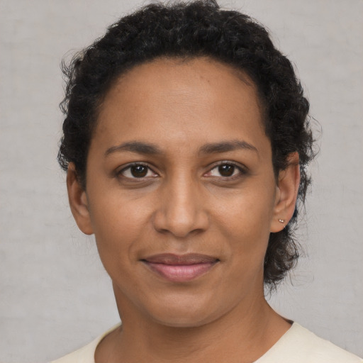 Joyful black adult female with short  black hair and brown eyes