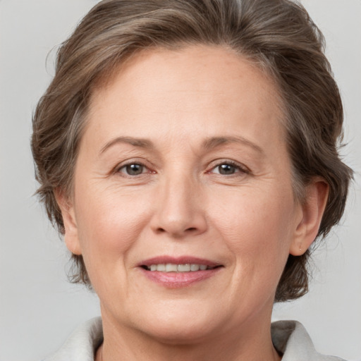 Joyful white adult female with medium  brown hair and grey eyes