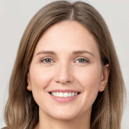 Joyful white young-adult female with long  brown hair and grey eyes