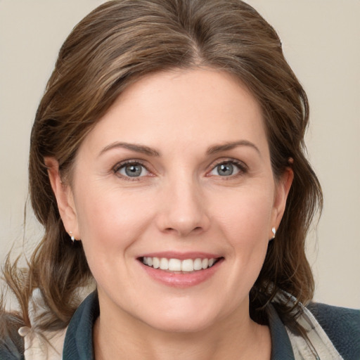 Joyful white young-adult female with medium  brown hair and grey eyes