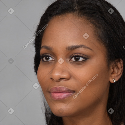 Joyful black young-adult female with long  black hair and brown eyes