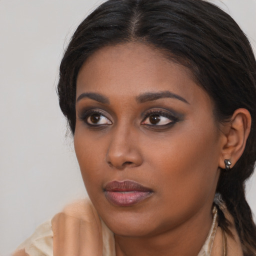 Joyful black young-adult female with long  brown hair and brown eyes