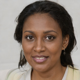 Joyful black adult female with medium  brown hair and brown eyes