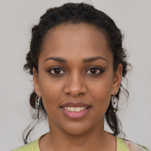 Joyful black young-adult female with short  black hair and brown eyes