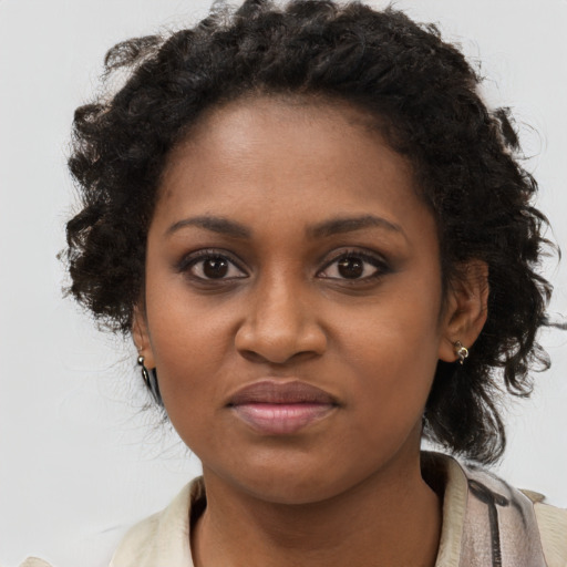 Joyful black young-adult female with long  brown hair and brown eyes