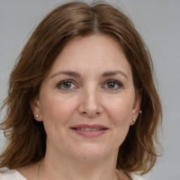 Joyful white adult female with medium  brown hair and grey eyes