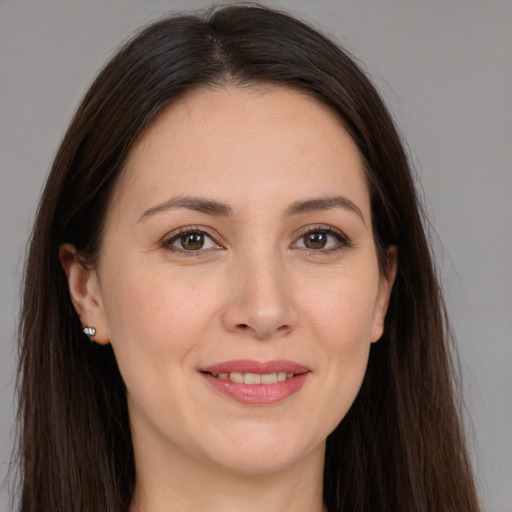 Joyful white adult female with long  brown hair and brown eyes