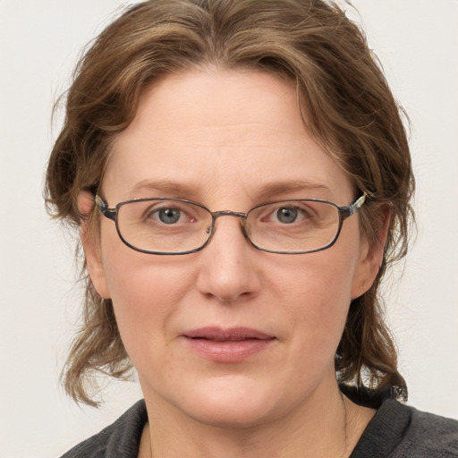 Joyful white adult female with medium  brown hair and blue eyes