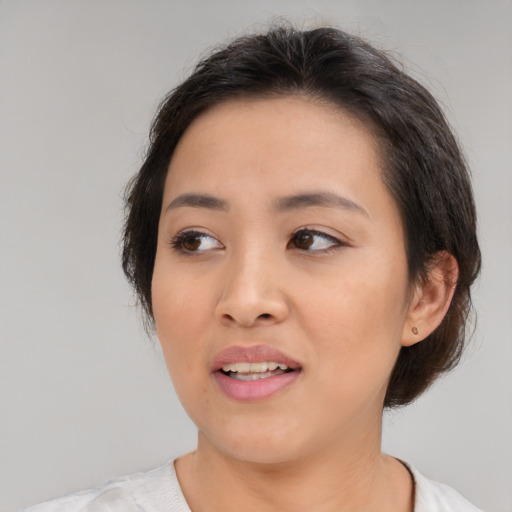 Joyful asian young-adult female with medium  brown hair and brown eyes