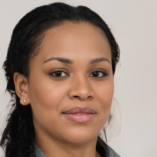 Joyful black young-adult female with long  brown hair and brown eyes