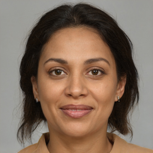 Joyful latino adult female with medium  brown hair and brown eyes