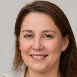 Joyful white adult female with long  brown hair and grey eyes