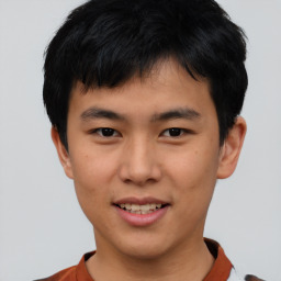 Joyful asian young-adult male with short  black hair and brown eyes