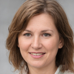 Joyful white adult female with medium  brown hair and grey eyes