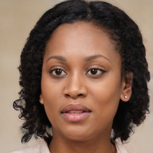 Joyful black young-adult female with long  brown hair and brown eyes