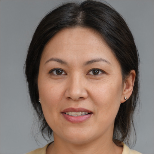 Joyful asian adult female with medium  brown hair and brown eyes
