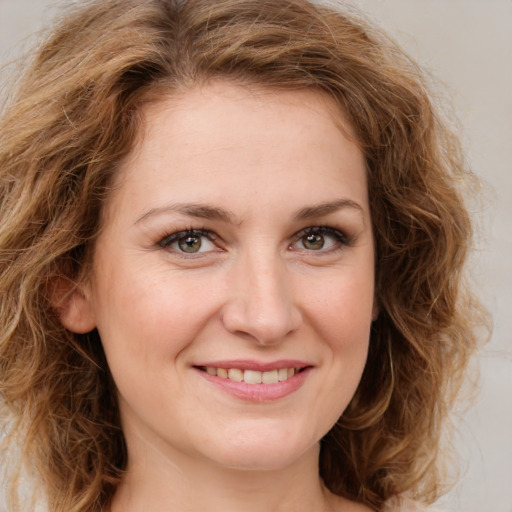 Joyful white young-adult female with medium  brown hair and green eyes