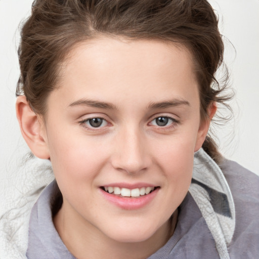 Joyful white child female with medium  brown hair and grey eyes