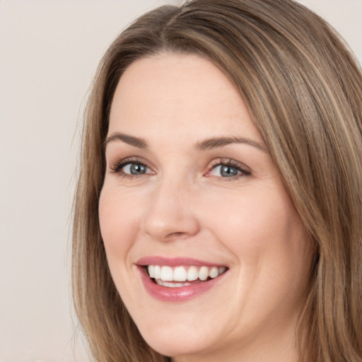 Joyful white young-adult female with long  brown hair and brown eyes