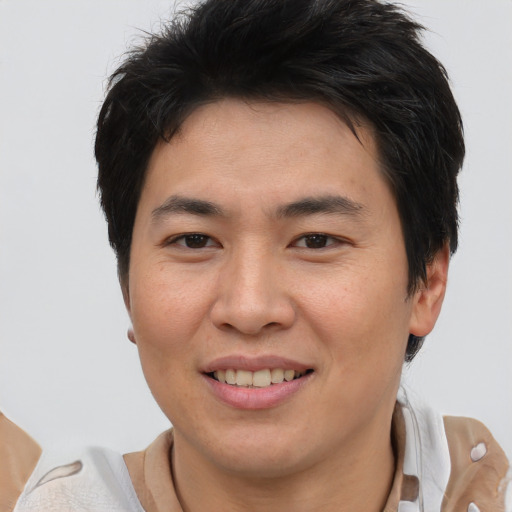 Joyful asian young-adult male with short  brown hair and brown eyes
