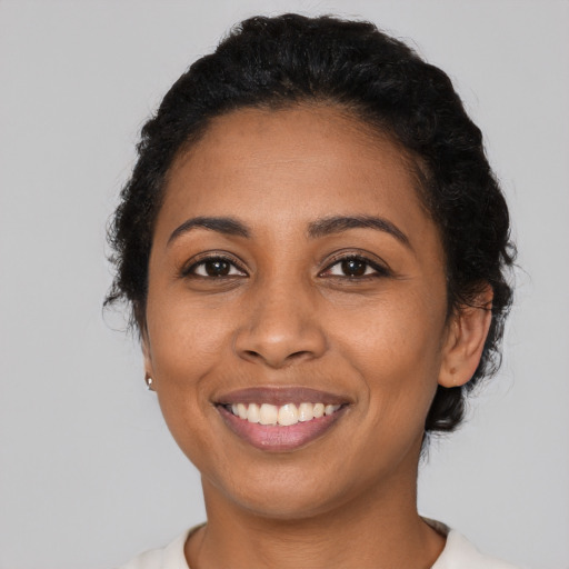 Joyful latino young-adult female with short  black hair and brown eyes
