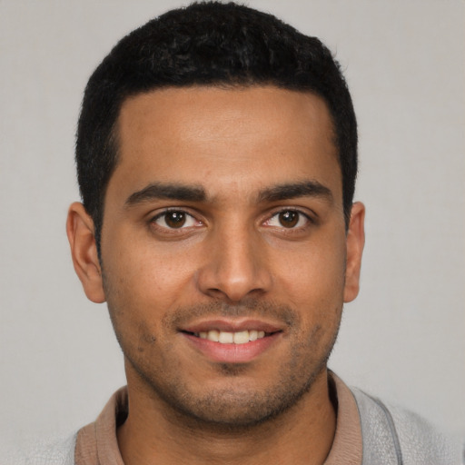 Joyful latino young-adult male with short  brown hair and brown eyes