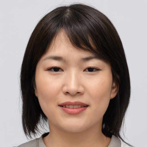 Joyful asian young-adult female with medium  brown hair and brown eyes