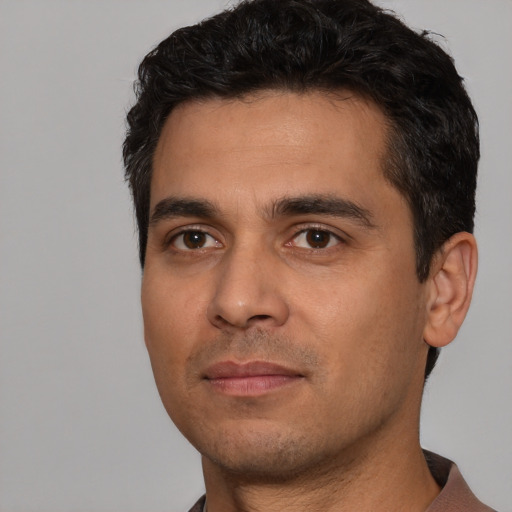 Joyful white young-adult male with short  black hair and brown eyes