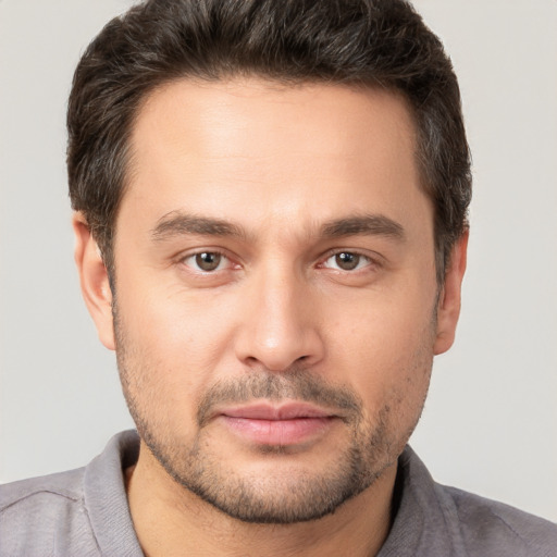 Joyful white young-adult male with short  brown hair and brown eyes