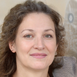 Joyful white adult female with long  brown hair and grey eyes