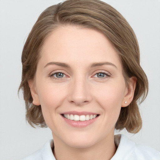 Joyful white young-adult female with medium  brown hair and grey eyes