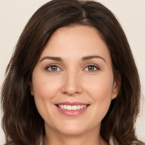 Joyful white young-adult female with long  brown hair and brown eyes