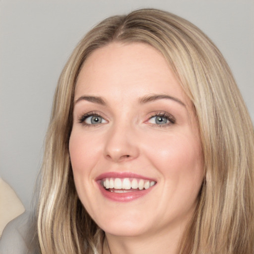 Joyful white adult female with long  brown hair and blue eyes