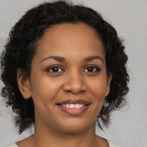 Joyful black young-adult female with medium  brown hair and brown eyes