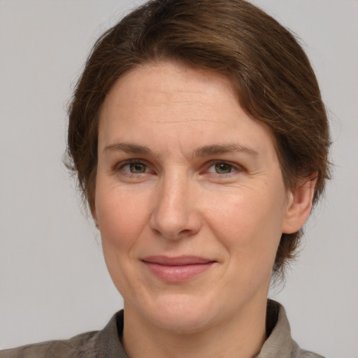 Joyful white adult female with medium  brown hair and grey eyes